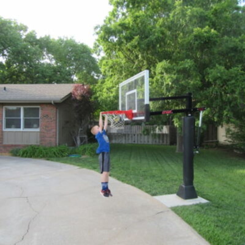 First Team Attack In Ground Adjustable Basketball Hoop Child Hanging From Lowered Goal